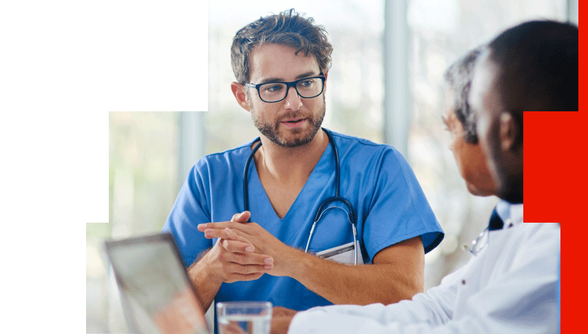 Oncologist in scrubs discussing precision medicine treatment options with a colleague