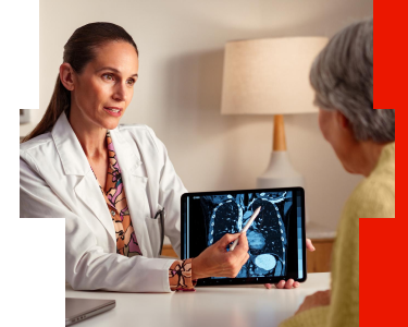 Oncologist reviewing a chest CT scan with an older patient to discuss lung cancer treatment options