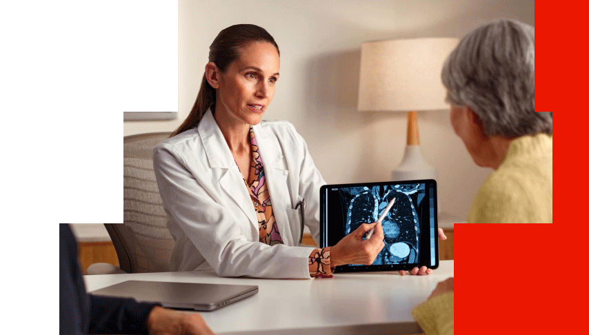 Oncologist reviewing a chest CT scan with an older patient to discuss lung cancer treatment options